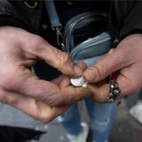 Eine Crack-Abhängige bereitet ihre Crack-Pfeife vor und zerbröselt dazu den Crack-„Stein“ in ihrer Hand.