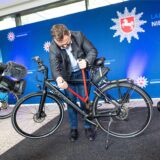 Ein Beamter der niedersächsischen Polizei demonstriert mit einem Bolzenschneider, wie Diebe ein Fahrradschloss knacken können