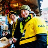 BVB-Fans stehen an einem Glühweinstand auf dem Dortmunder Weihnachtsmarkt.