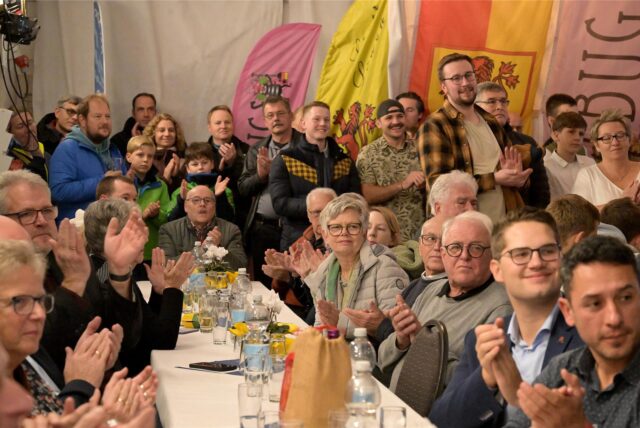 Viele Menschen klatschen in die Hände.