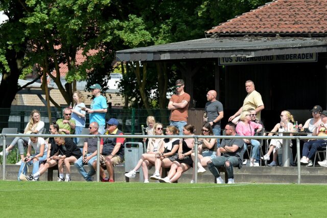 Fans sitzen beim TuS Niederaden am Spielfeldrand.