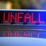 Auf einem Polizeifahrzeug warnt eine Leuchtschrift vor einer Unfallstelle.