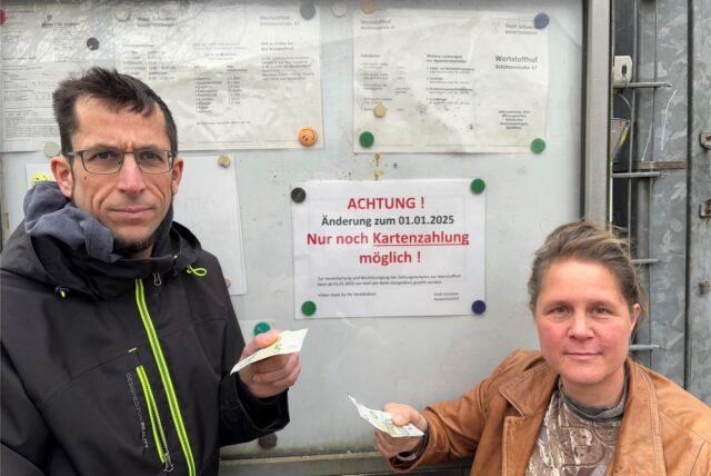 Sandra Rudeck und Oliver Bozetti aus Schwerte stehen am Wertstoffhof vor dem Schild.