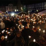 Eine Menschenmenge mit brennenden Wunderkerzen auf dem Weihnachtsmarkt in Werne