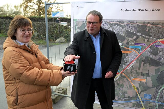 Straßen.NRW-Direktorin Dr. Petra Beckefeld hält den Knopf, mit dem NRW-Verkehrsminister Oliver Krischer die neue, festinstallierte Ampel an der Kreuzung An der Wethmarheide/Dortmunder Straße in Betrieb nimmt.