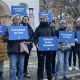 Eine Tierschützerin hält ein Plakat mit der Aufschrift: „Je hilfloser ein Leben ist, desto größer ist sein Anrecht auf menschlichen Schutz vor menschlicher Grausamkeit.“ hoch.