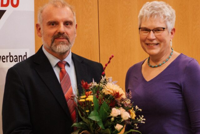 Unnas Bürgermeister Dirk Wigant mit Blumen von der Stadtverbandsvorsitzenden Beatrix Wieczorek, die neben ihm steht.