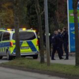 Drei Polizisten stehen an der Aral-Tankstelle in Lünen-Brambauer neben zwei Polizei-Autos