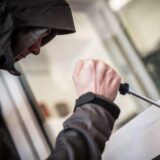 Ein Mann demonstriert, wie Einbrecher Fenster aufhebeln.
