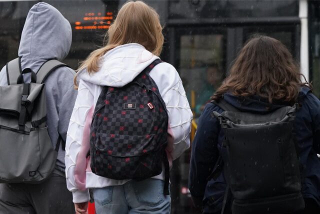 Schulkinder stehen vor einem Bus.