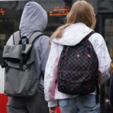 Schulkinder stehen vor einem Bus.