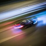 Zu Lichtspuren verwischt sind die Fahrzeuge auf einer Autobahn.