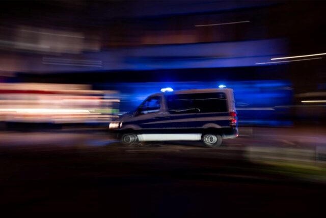 Ein Polizeifahrzeug fährt schnell, der Hintergrund ist verschwommen.