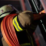 Ein Feuerwehrmann wickelt einen Schlauch ab