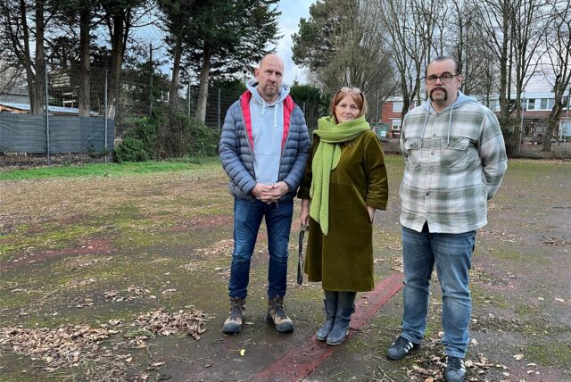 Vater Thomas Thurau, Schulleiterin Kirsten Laroussi und OGS-Leiter Arnulf Glatkowski (v.l.) stehen auf dem maroden Sportplatz der Siegfried-Drupp-Grundschule.
