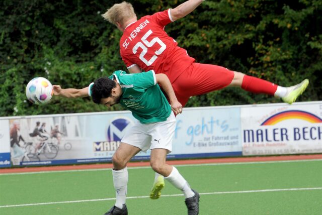 Nick Wachholz mit der Rückennummer 25 (SC Hennen) im Flug auf den Rücken von Gianluca Zocco von der SG Eintracht Ergste.
