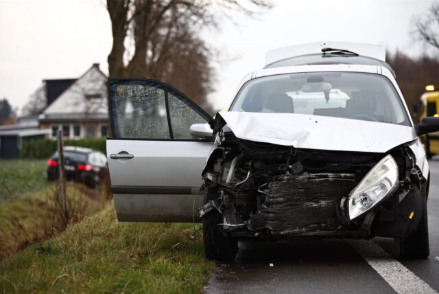Ein silbernes Fahrzeug steht demoliert am Straßenrand. Ein anderes im Feld.