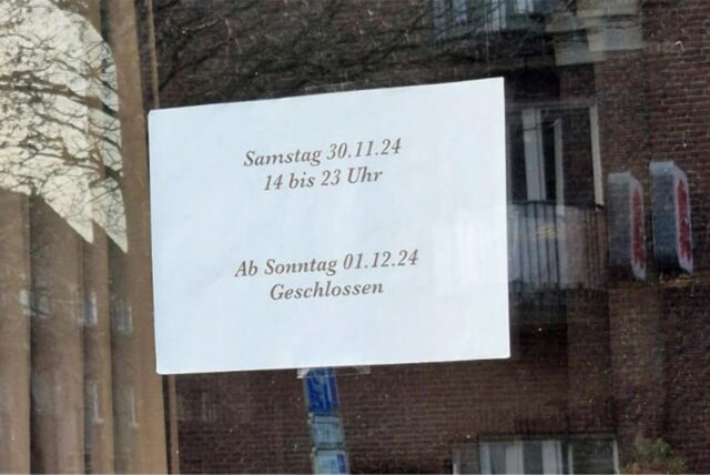 Ein Zettel in einem Schaufenster mit der Aufschrift „Samstag 30.11.24 14 bis 23 Uhr Ab Sonntag 01.12.24 Geschlossen“.