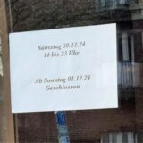 Ein Zettel in einem Schaufenster mit der Aufschrift „Samstag 30.11.24 14 bis 23 Uhr Ab Sonntag 01.12.24 Geschlossen“.