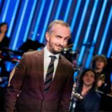 Jan Böhmermann steht im Anzug vor dem Rundfunk Tanzorchester Ehrenfeld.
