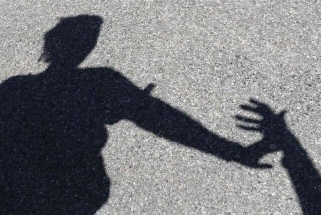 Der Schatten einer Frau, die eine fremde Hand abwehrt. (Symbolbild)