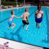 Kinder springen im Freibad Brambauer ins Becken.