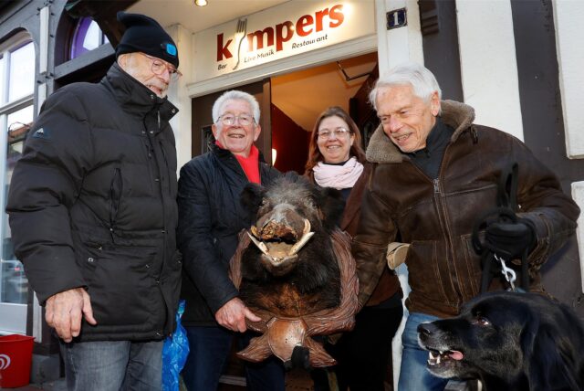 Sandra Herstell und drei Stammgäste vor dem Kümpers in Kamen. Sie halten den Keiler in den Händen.