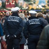 Polizeibeamte gehen über einen Weihnachtsmarkt. (Symbolbild)