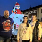 Sascha, Netti und Annika Kamrau stehen in ihrem weihnachtlich geschmückten Garten.
