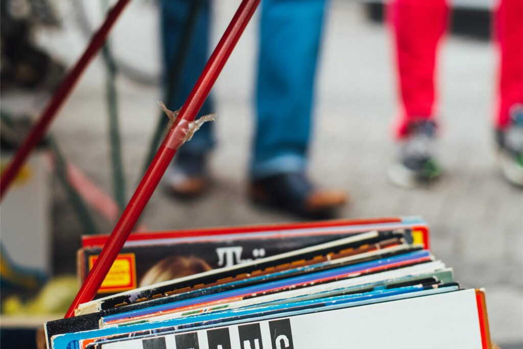 An einem Trödelmarktstand steht eine Kiste mit Schallplatten - vorne ist das Cover einer Platte von Sting zu sehen. An einem Trödelmarktstand steht eine Kiste mit Schallplatten - vorne ist das Cover einer Platte von Sting zu sehen.