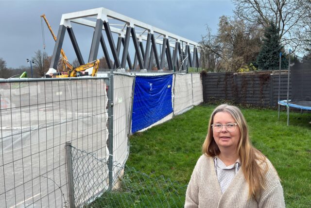 Sylvia Zipp steht in ihrem Garten. Direkt hinter dem Gartenzaun beginnt die A1-Brückenbaustelle an.