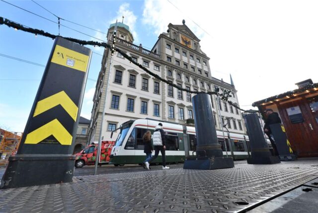 Sicherheitspoller stehen vor dem Rathaus am Eingang des Christkindlesmarktes.
