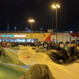 Viele Demonstrierende stehen an der Nordseite des Dortmunder Hauptbahnhofs, eine große Flagge wird aufgespannt.