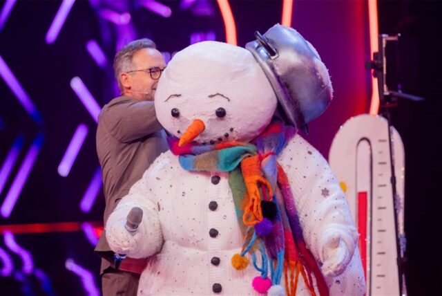 Die Figur „Der Schneemann“ steht in der Prosieben-Show „The Masked Singer“ auf der Bühne neben Moderator Matthias Opdenhövel.