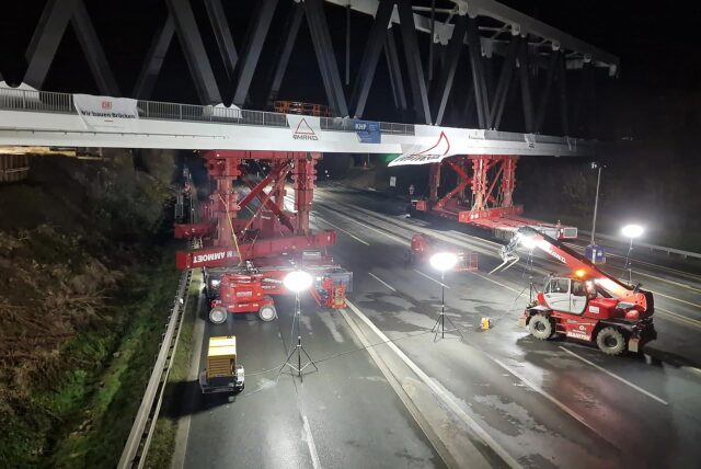Eine Brücke der Deutschen Bahn wird am 8. Dezember 2024 nachts mit Hilfe von Baumaschinen in ihre Position über der A1 bei Unna gebracht.