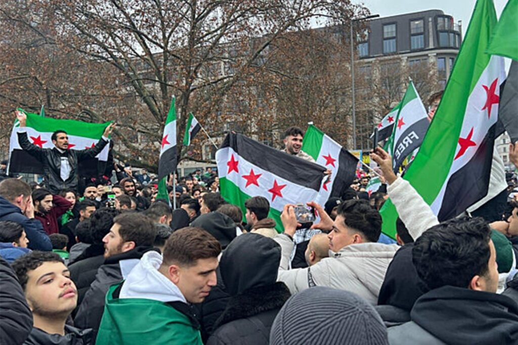 Menschen in Berlin feiern mit Flaggen der Syrische Republik auf dem Oranienplatz den Sturz des Assad-Regimes. Menschen in Berlin feiern mit Flaggen der Syrische Republik auf dem Oranienplatz den Sturz des Assad-Regimes.
