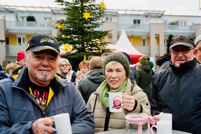 Besucher stehen auf dem Weihnachtsmarkt in Iserlohn-Hennen und halten eine Tasse in der Hand