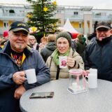 Besucher stehen auf dem Weihnachtsmarkt in Iserlohn-Hennen und halten eine Tasse in der Hand