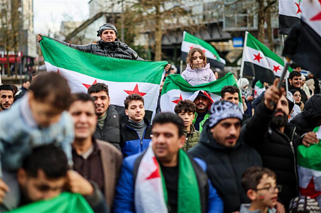 Menschen schwenken auf einer Kundgebung in Wuppertal Fahnen der Syrische Republik und singen. Sie feiern den Sturz des Assad-Regimes in Syrien. Menschen schwenken auf einer Kundgebung in Wuppertal Fahnen der Syrische Republik und singen. Sie feiern den Sturz des Assad-Regimes in Syrien.