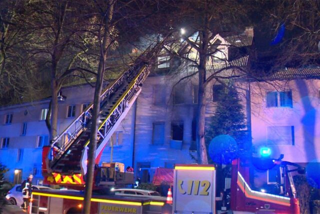 Die Feuerwehr mit einer Drehleiter Menschen aus dem Gebäude retten.