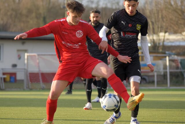 Noel Barucha (im roten Trikot) klärt den Ball vor dem Gegner.