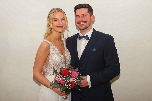 Lea und Sebastian Blömer stehen vor einer weißen Wand im Holzwickeder Standesamt.