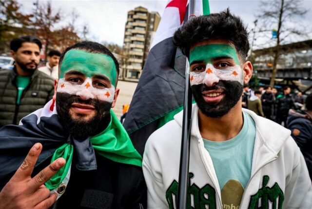 Demonstranten haben sich für eine Kundgebung in Wuppertal eine syrische Flagge ins Gesicht gemalt.
