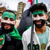 Demonstranten haben sich für eine Kundgebung in Wuppertal eine syrische Flagge ins Gesicht gemalt.