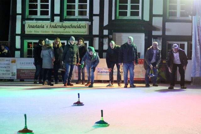 Mehrere Persinen stehen auf dem Eis und betreiben Eisstockschießen