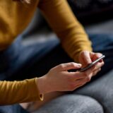 Eine Frau hält ein Smartphone in den Händen.