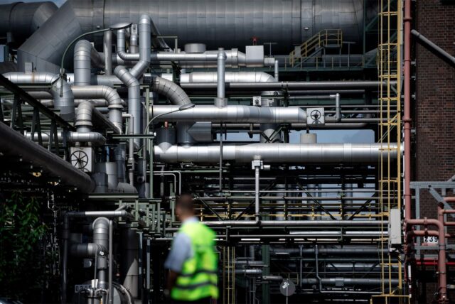 Ein Mitarbeiter des Werkschutzes steht vor Rohren auf dem Gelände des Evonik-Chemieparks.