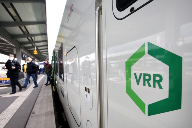 Aus einem Nahverkehrszug mit dem Firmen-Logo des Verkehrsverbundes Rhein-Ruhr (VRR) steigen Fahrgäste aus.