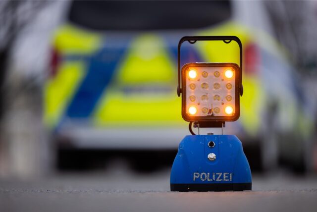 Ein Warnlicht mit der Aufschrift „Polizei“ steht auf der Straße vor einem Einsatzfahrzeug der Polizei. Ein 21-Jähriger aus Dortmund ist bei einem Unfall im Sauerland ums Leben gekommen. (Symbolbild)