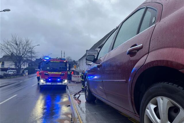 Ein rotes Auto steht auf einem Abschleppwagen. Ein Feuerwehrauto parkt entgegen der Fahrtrichtung auf der Lünener Straße Höhe der Einmündung „Auf den Goldäckern“.